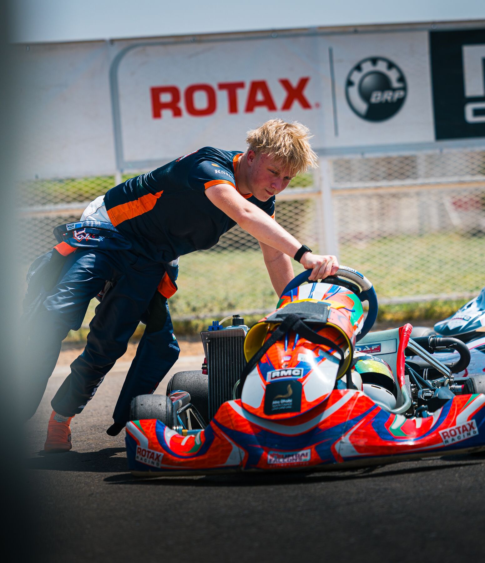 Damian Knorr pushing his kart in the paddock, Al Ain