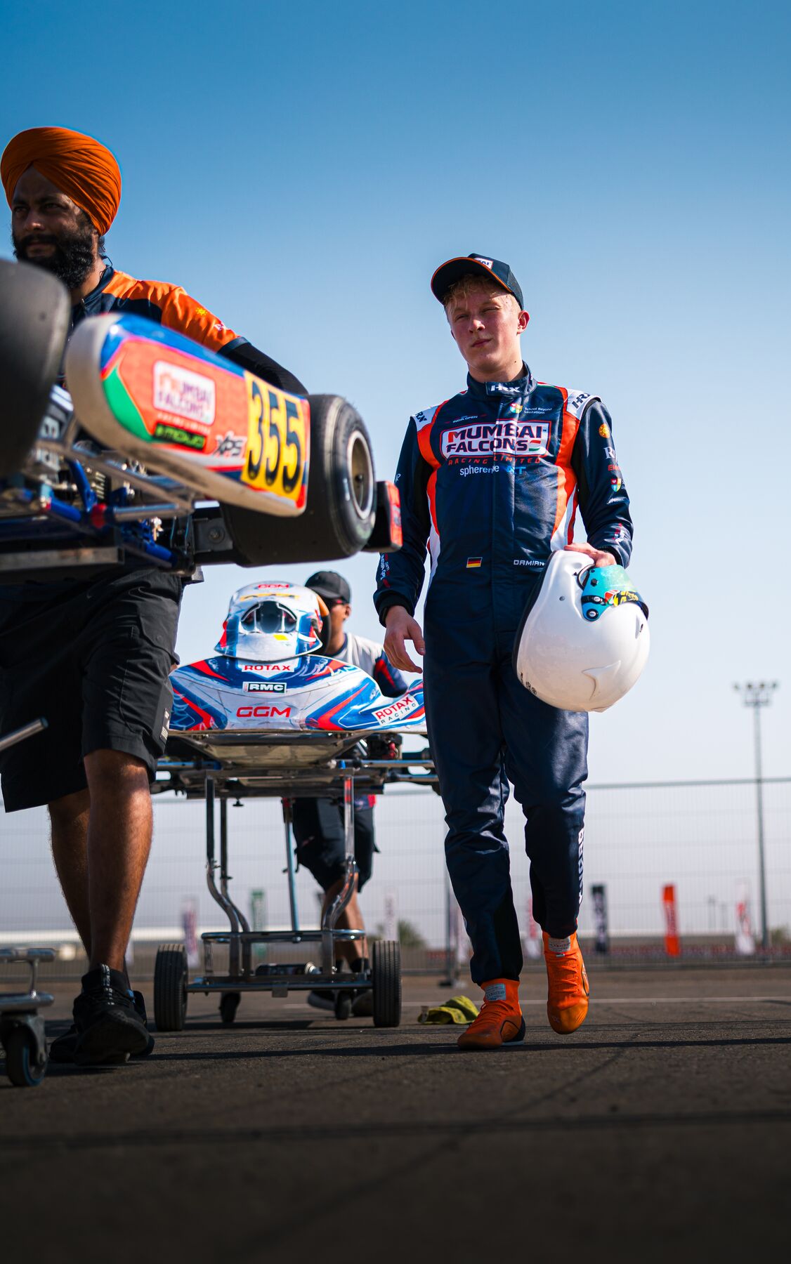 Damian Knorr walking to the grid with his kart, Al Ain